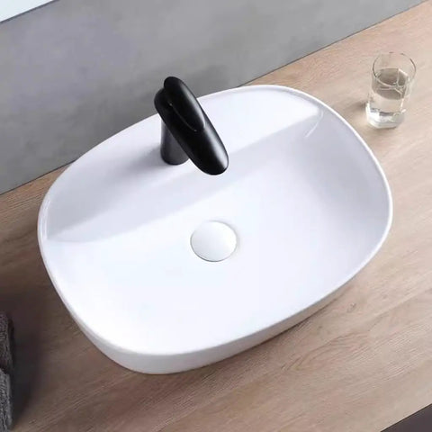 Top view of USZWBY Vessel Sinks Minimalist Ceramic Table Basin with black faucet, ideal for modern bathrooms.
