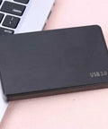 No Fuss 2.5 Inch SATA External Hard Drive Enclosure And Portable Docking Station With USB 3.0 Port on desk next to laptop.