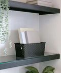 No Sweat Home Organization Decorative Storage Basket For Cube Systems And Desk Shelves, Sturdy Plastic Woven Organizer With Total Game Changer And Clean Setup Vibes In Sleek Black Medium on a shelf holding books.