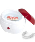 Portable Ultrasonic Denture And Retainer Cleaner Case With Automatic Wash Feature And Built In Filter For Glasses Jewelry And False Teeth Compact Straight Up Spotless Daily Essential with dentures and retainer in water.