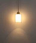 Close-up of three pack 1-light industrial farmhouse pendant light with frosted glass and brushed nickel finish, illuminated