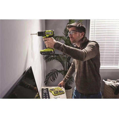 Man using Hard Hitting 18V Brushless Drill And Impact Driver Kit With Two 1 5Ah Batteries on a wall in a home setting.