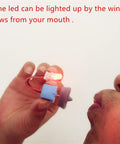 Close-up of person blowing on small Wind Hydroelectric Generator Model For STEM Classrooms, LED lights up demonstrating AC wind power