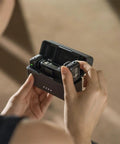 Person holding the Plug-And-Play All In One Wireless Microphone System With 2 Transmitters And 1 Receiver in charging case