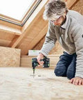 Built Tough 18V Compact Cordless Drill Workhorse Kit Featuring Quick Charge Dual Batteries A Reliable Smooth Operator For Tight Quarters And Furniture Buildouts Includes Keyless Chuck And Magnetic Bit Caddy in use on a wooden floor.
