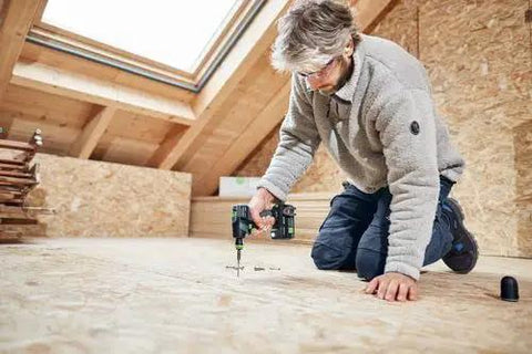 Built Tough 18V Compact Cordless Drill Workhorse Kit Featuring Quick Charge Dual Batteries A Reliable Smooth Operator For Tight Quarters And Furniture Buildouts Includes Keyless Chuck And Magnetic Bit Caddy in use on a wooden floor.
