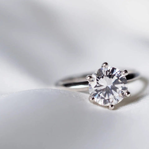 Close-up of a silver diamond ring on a soft surface. Ultra Concentrated Ultrasonic Jewelry Cleaner Solution For Home Use Delivers Killer Deep Clean For Rings Watches Glasses Earrings Coins Works With Diamond Gold Silver 1 Quart Mix With Water.