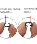 Bike Cable Housing Guide Clips Pack of 4mm and 5mm Housing held to show size comparison and application for brakes and shifters.