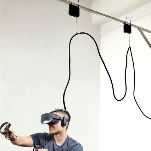 Person using VR headset with ceiling cable suspension system for immersive experience indoors.