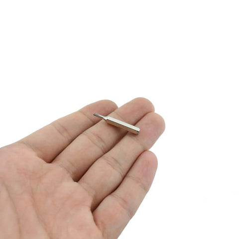 Hand holding a small bit from Beefed-Up Torx Bit Set For Pros And DIYers, 28mm Length, 10-Piece T1 Through T10 Screwdriver Bits In S2 Alloy Steel