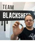 Person holding Crossfire Micro Receiver V2 Super Tiny Lightweight UHF Long Range For Mini And Micro Quads in front of logo.