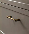 Antique Brass Zinc Alloy Cabinet Pulls Three And Three Quarter Inch Hole Center Vintage Drawer Handles For Kitchen Cupboard Bathroom Dresser Cabinets Hardware With Classic Vibe And Easy Grip Design To Elevate Any Room shown installed on a grey cabinet drawer.