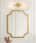 Mid Century Modern Crystal Glass Shade 2 Light Gold Brushed Brass Wall Sconces in bathroom with gold framed mirror