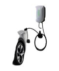 Premium Level Two Electric Vehicle Charger With J1772 Connector And Adjustable Wall Box EVSE mounted to a wall with a vehicle tire nearby.