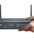 Rock Solid Plug And Play Next Generation Firewall With 2.5 GBPS Throughput And One Year TotalSecure Advanced License held by a hand.