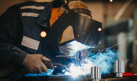 Welder using welding table with 12 Pack Welding Table Fixture Pins Five Eighths By One By One Point Five Inches Aluminum Quick Setup Fixturing Kit