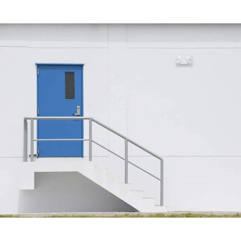Built Legit Dual Head LED Emergency Light With Multi Voltage And Remote Option For Zero Hassle Snap Fit Install beside blue door.