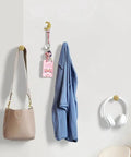 Sun Moon Cabinet Knobs Set on wall holding bag and headphones, solid brass, antique finish, celestial hardware for decor.