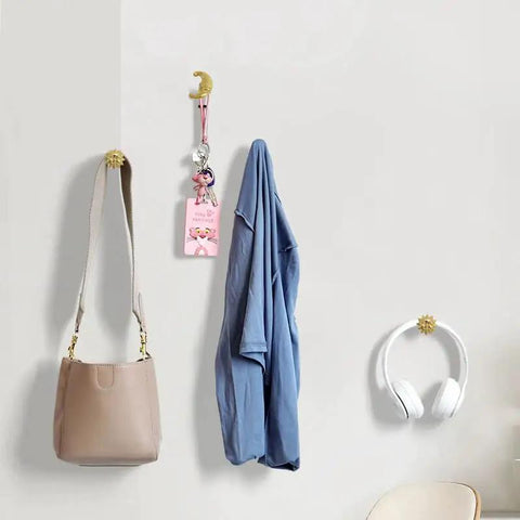 Sun Moon Cabinet Knobs Set on wall holding bag and headphones, solid brass, antique finish, celestial hardware for decor.