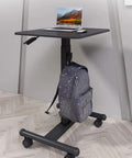 Smooth Casters Let You Slide This Beast Anywhere Upgrade Your Daily Grind With Height Adjustable Mobile Standing Desk with laptop and backpack.