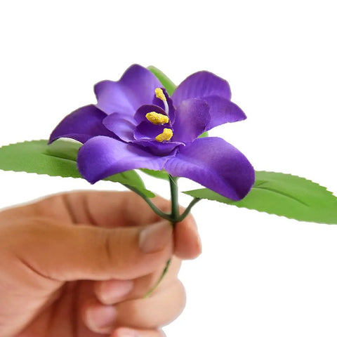 Hand holding artificial purple flower for Expandable Faux Ivy Fence Privacy Screen For Balcony And Patio Outdoor Decor With Artificial Hedges