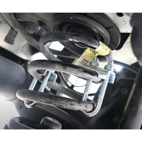 Adjustable Coil Spring Lowering And Leveling Kit installed on vehicle suspension, showcasing shock absorber clamp for car tuning.