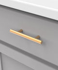 10 Pack 3-Inch Center Cabinet Handles with Brushed Brass Finish, modern bar pull on gray drawer front.