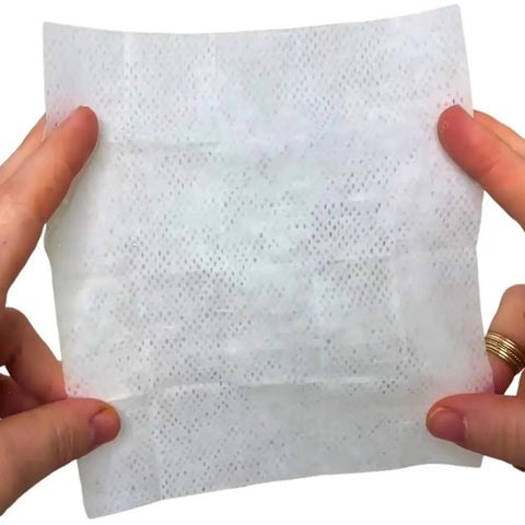 Person holding Shout Instant Stain Remover Wipes 12 Count, 5 By 6 Inch towelette for quick stain removal on various surfaces.