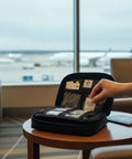 MediKit medical kit with 20 medications in a black zip case, opened on a round table in an airport lounge.