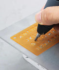 Person using ten piece carbide point engraver bits set for rotary tool on plastic stencil, demonstrating use for engraving