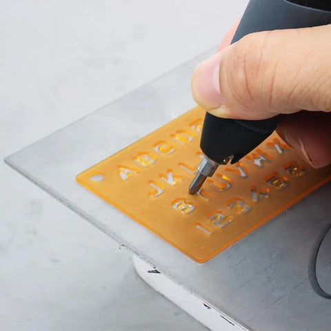 Person using ten piece carbide point engraver bits set for rotary tool on plastic stencil, demonstrating use for engraving