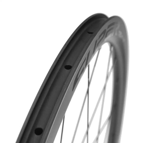 Close-up of a carbon fiber rim on a 38mm Tubeless Disc Brake Road Wheelset 700c Carbon Fiber Toray T700 With 25mm Rim Shimano 8 To 12 Speed UCI Approved And EN Certified Lightweight Beast For Fast Climbs And Smooth Descents 2 Year Warranty.