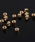 Hexagonal brass standoffs from the Three Millimeter Brass Standoff Kit For PCBs And DIY Electronics on a reflective surface.