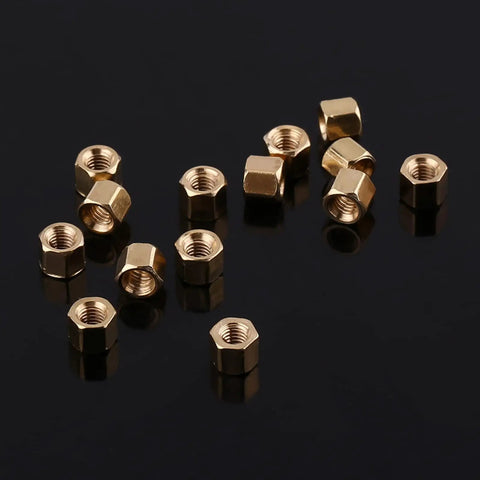Hexagonal brass standoffs from the Three Millimeter Brass Standoff Kit For PCBs And DIY Electronics on a reflective surface.