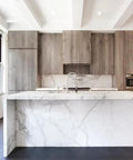 Modern kitchen featuring a marble countertop, reclaimed wood cabinetry, and large windows for natural light.
