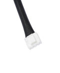 Automotive electrical connector on black braided hose; white plastic end, close-up.