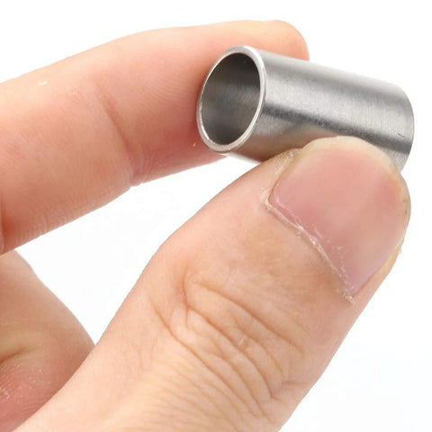 Close-up of B10–B12 conversion sleeve, stainless steel drill chuck adapter, held between fingers.