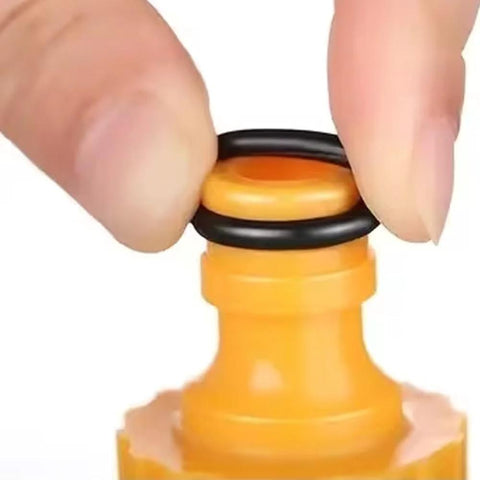 Rubber O-ring, black, being fitted onto orange bottle neck cap