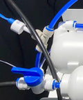 Close-up of blue One Quarter Inch Locking Clips 50 Pack For Reverse Osmosis RO Water Line Quick Connect Fittings installed on system.