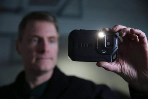 Person holding Pocket Thermal Camera C2 for home and building inspections, capturing thermal images.