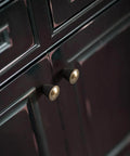 Six Pack Antique Brass Cabinet Knobs With Fluted Trumpet Ends installed on dark cabinetry