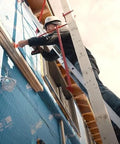 Metaltech pump jack brace 2201 installed on blue exterior wall with a worker on a ladder.