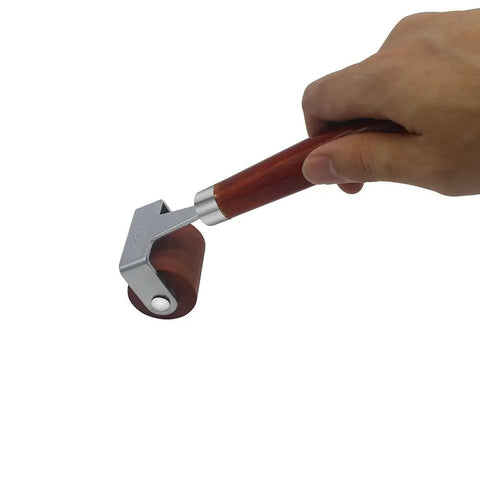 Soft Rubber Brayer Roller With Wooden Handle For Printmaking And Inking Blocks, hand holding smooth ink roller, side view