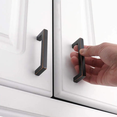 Oil Rubbed Bronze Cabinet Pulls 3 Inch 10 Pack Solid Metal Handles installed on white cabinet with smooth rounded edges