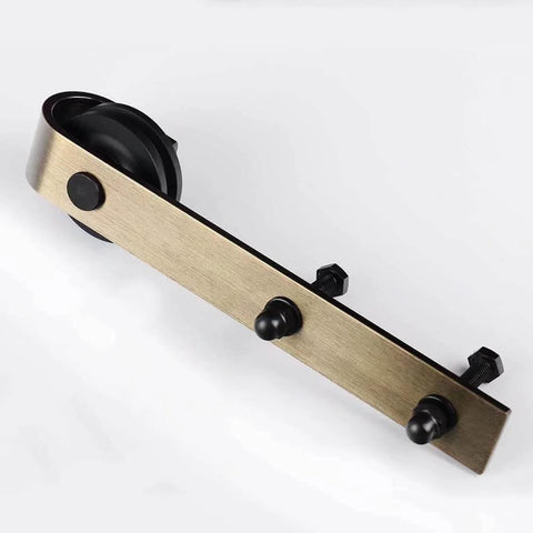 Brass Sliding Barn Door Hardware Kit In Brushed Gold Finish Heavy Duty Carbon Steel Track System With 200 Lb Weight Capacity Fits Standard Interior Doors Includes Two 1000 Millimeter Tracks Five Spacers Two Rollers Two Stoppers And Anti Jump close-up view of roller.
