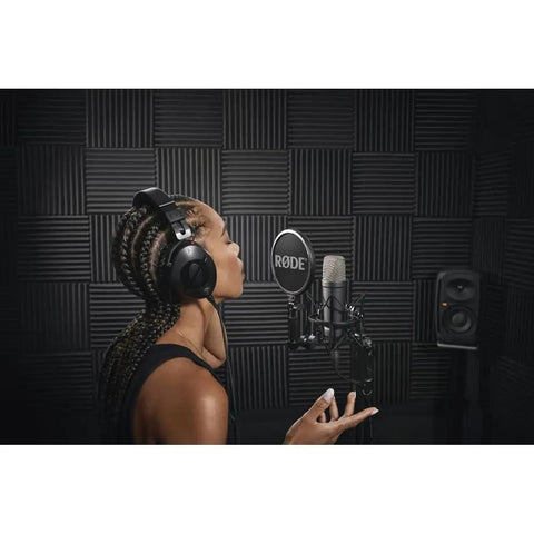 Person using Signature Series Large Diaphragm Condenser Mic With Shock Mount, Pop Filter, And XLR Cable in sound studio