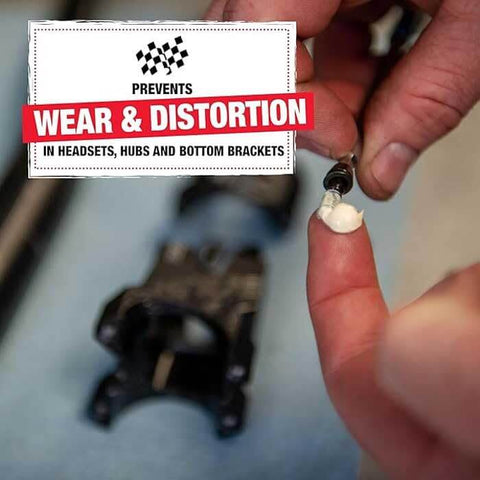 Applying Heavy Duty Built Tough Bike Grease With High Pressure And Water Resistant Formula For Rust And Corrosion Protection Of Headsets Hubs And Bottom Brackets 3.5 Oz Ideal For Mountain And Road Bikes to bike component close-up.