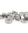 Premium 10 Pack Stainless Steel SF605ZZ Flanged Deep Groove Ball Bearings 5x14x5mm Double Shielded arranged in a pile.
