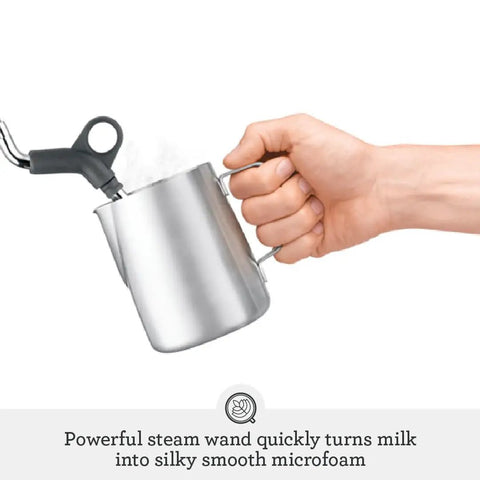 Pro Level Espresso Machine With A Rock Solid Steam Wand For Silky Microfoam And Volumetric Shot Control In Heavy Duty Brushed Stainless Steel Frame pouring milk into a steam wand.
