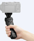 Person holding Wireless Bluetooth Shooting Grip And Tripod For Still Photos And Video Perfect For Vlogging Cable Free Remote Commander